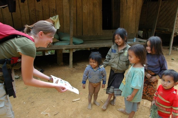 Handing Out a Book to Village Kids
